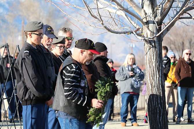 A Marine veteran places a wreath on a grave at Saturday's Wreaths Across America ceremony in Garden Cemetery in Gardnerville.