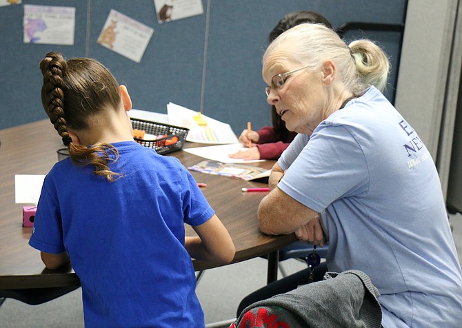Cherie Loorz, reading interventionist at Empire Elementary School, helps a first-grade student with reading skills.
