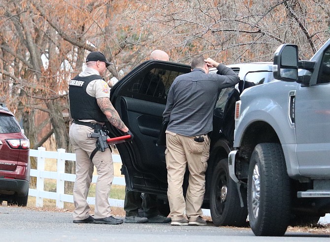 Sheriff's investigators discuss a shooting in Genoa on Thursday afternoon.