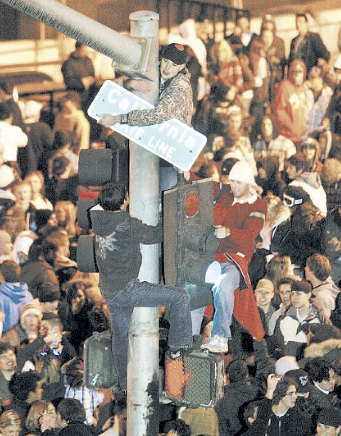 It has been 15 years since New Year’s Eve at Stateline was quite this rambunctious. All three of the young men climbing the pole were arrested shortly after in 2008. Photo by Jim Grant/Tahoe Daily Tribune