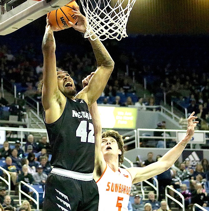 Nevada's K.J. Hymes scores on a layup in the first half with Fresno Pacific's Harrison Pennisi trying to stop the shot. Nevada defeated Fresno Pacific 92-59 Saturday night at the Lawlor Events Center.