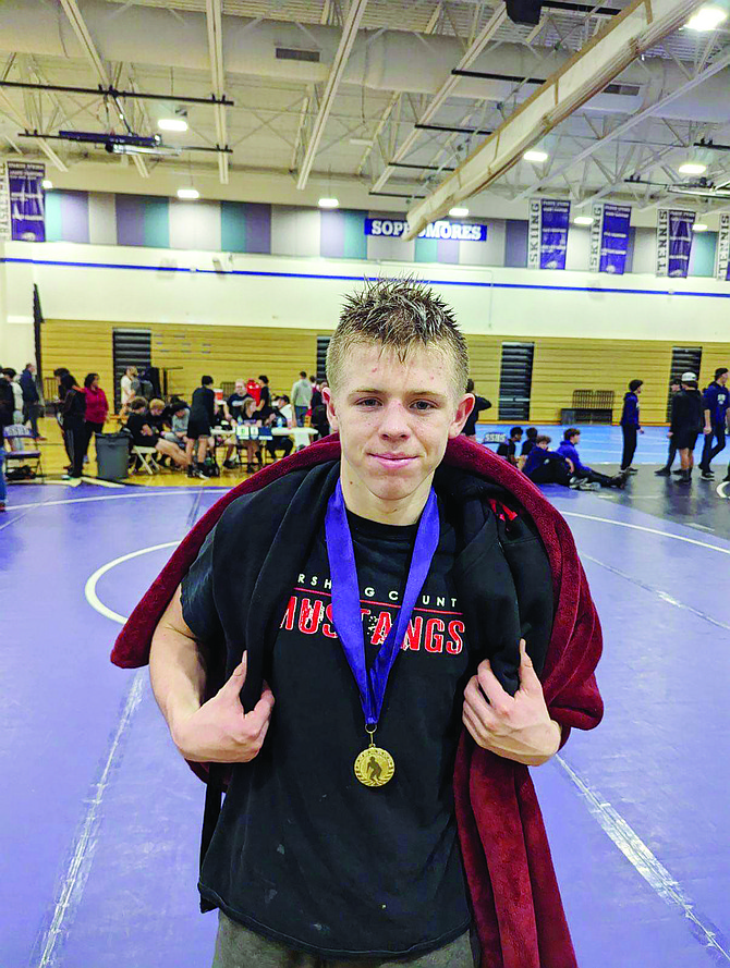 Pershing County freshman Israel Knight displays his gold medal at the Cougar Bash in the 144-pound weight class.