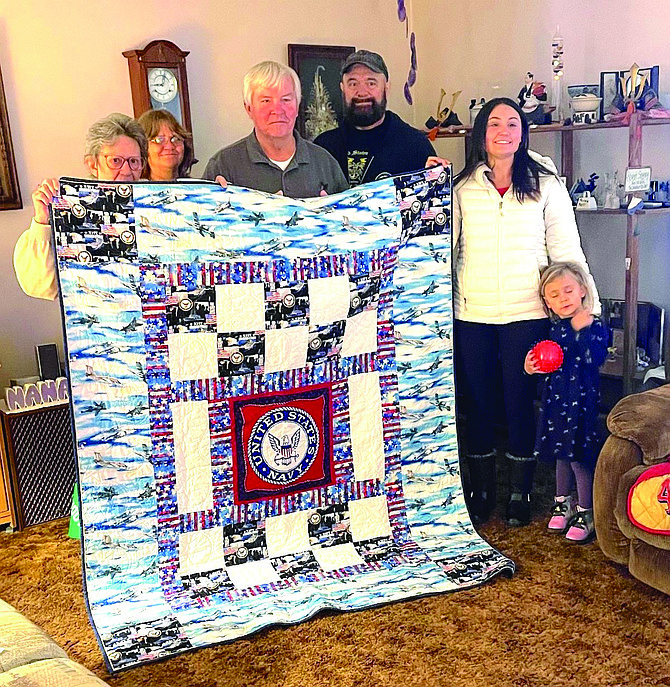 Displaying the Quilt of Valor recently presented to Pat LeClaire are, from left, his wife Loraine, daughter Jennifer, LeClaire, son-in-law Jerry Briggs, granddaughter Felicia and great-granddaughter Stella Harper.