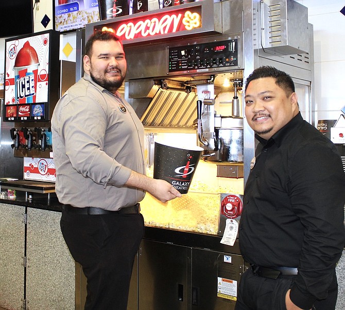 Samuel Tripp (left), assistant general manager, and Anthony Angeles, general manager of the Galaxy Theatre in Carson City, prepare a tub of popcorn.