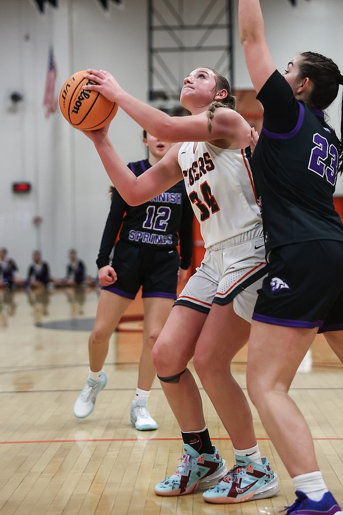 Douglas High’s Hailee Koontz works for a shot in the paint against a Spanish Springs defender Saturday. Koontz posted a game-high 14 points in the win as the Tigers took over second place in the Class 4A North league standings.