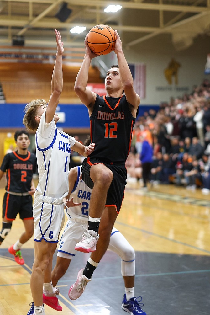 Reese Torres, of Douglas High boys basketball, fades away for a bucket against Carson Friday night. Torres had 11 points in the Tigers' 72-37 win.