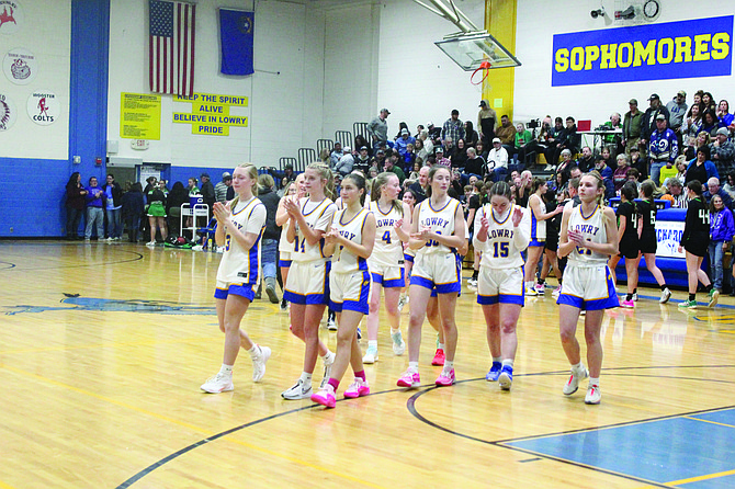 The Lowry High School girls basketball teams walks towards the student body and band after its 76-39 win over Churchill County on Friday night in Winnemucca.