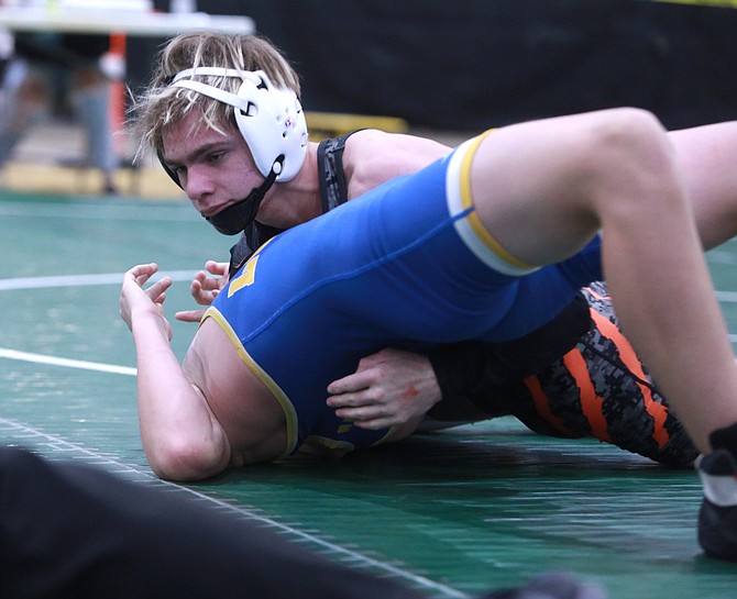 Douglas High's Cody Highfill works for a pin at the Earl Wilkens Invitational to start the season. Highfill has been a staple in the varsity lineup for the Tigers this winter.