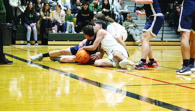 Battle Mountain’s Brodie Smith fights for a loose ball in Friday’s game against Oasis Academy.