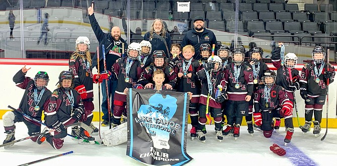 The Tahoe Grizzlies 10U team and coaching staff hold up a banner after winning their division at the 17th annual Tahoe Invitational Hockey Tournament.