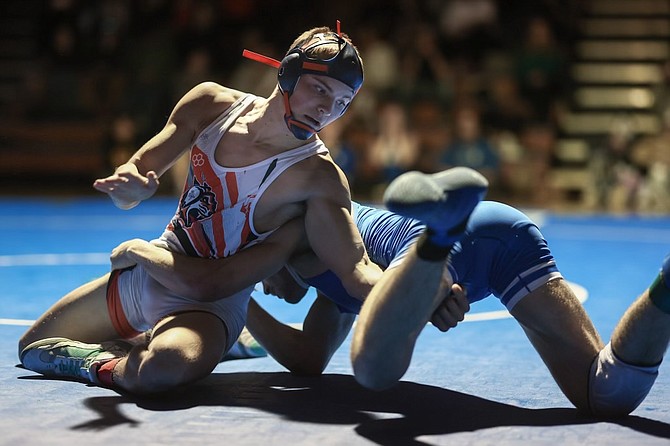 Douglas High’s Dalton Nixon reaches for leg control, during his 157-pound match against Carson Wednesday night. Nixon won by a 12-9 decision, but the Tigers fell to the Senators 44-33 as a team.
