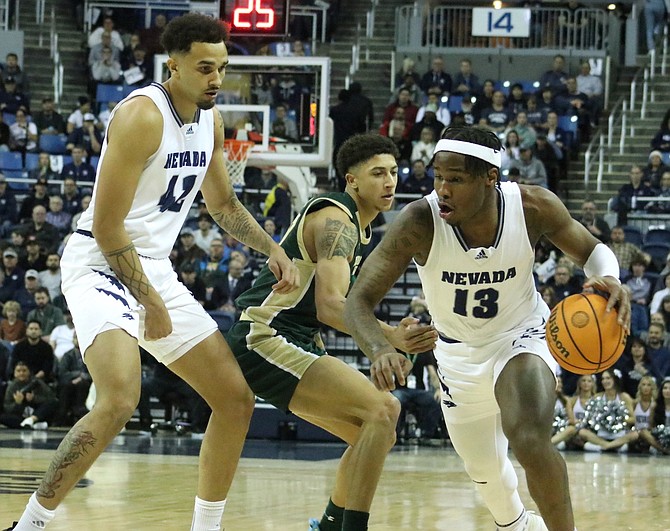 Nevada guard Kenan Blackshear (13), with help from forward K.J. Hymes (42), drives around Colorado State University’s Snookey Wigington in the Wolf Pack’s Jan. 24 game against Colorado State University.