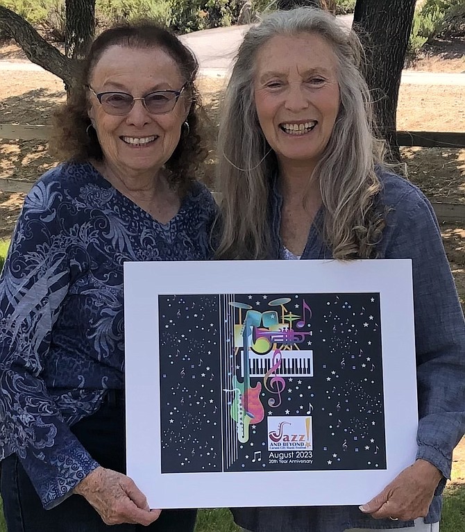 Jazz & Beyond committee member Elinor Bugli, left, and artist Carol Foldvary-Anderson show winning artwork, ‘Digital Collage Improv,’ used for the contest in 2023.