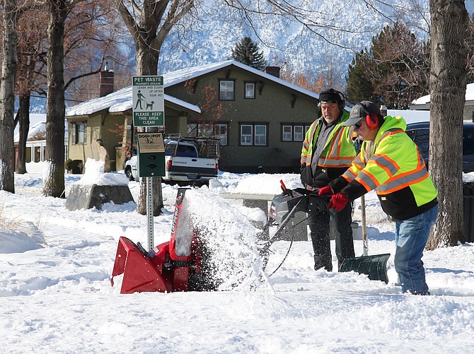 Workers from the Town of Minden clear the sidewalk at Minden Park on Monday morning.
