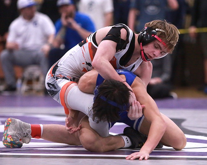Douglas High’s Cody Highfill battles for positioning against Carson’s Keona Basa, during their third place match at 120 pounds Saturday at Spanish Springs. Highfill qualified for state for the second straight year.
