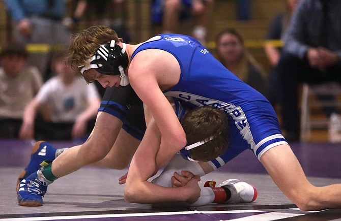 Carson High’s Jesse Oliva works against McQueen’s Cooper Sandoval in the 106-pound Class 5A North regional final Saturday. Oliva punched his ticket to the state wrestling tournament for the second season in a row.