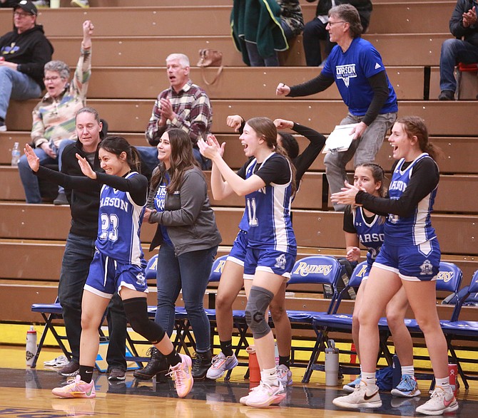 The Carson High girls basketball team celebrates off the bench after the final buzzer as the Senators bested Reed, 46-36, in the opening round of the Class 4A North regional playoffs.