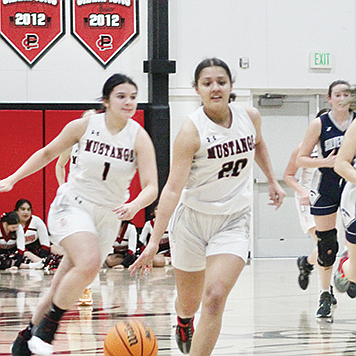Pershing senior Yasmine McKinney drives the ball across the court with backup from Kaylah Hanley, also a senior.