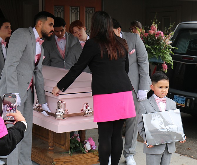 Lexi Rodriguez’s younger brother Trinidad, 6, right, leads the procession for her casket before it is lifted onto a carriage to be taken to Lone Mountain Cemetery Saturday.