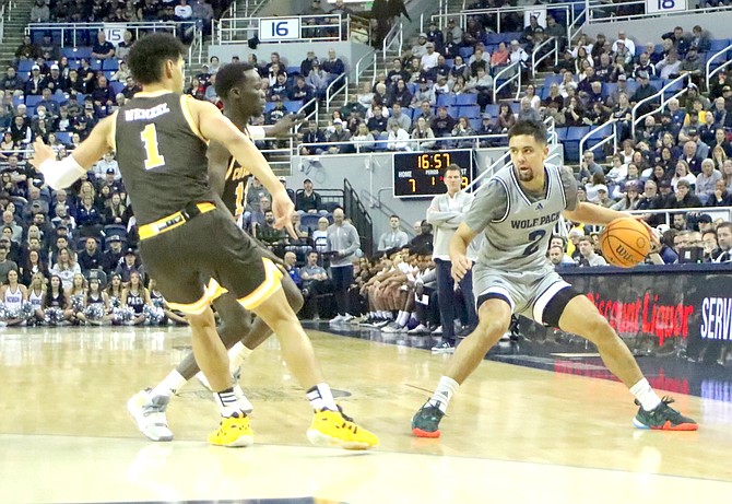 Nevada guard Jarod Lucas dribbles around Wyoming’s Brendan Wenzel (1) and Akuel Kot during a 76-58 win at Lawlor Events Center on Tuesday. Lucas finished with 19 points and eclipsed the 2,000-point scoring mark for his college career.