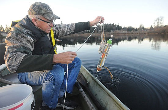 Doug Campbell of Snohomish uses a measuring tool to take a sample of water from near the center of Snohomish's Blackman Lake on Wednesday, Dec. 14, 2022. The work is part of a monthly water test volunteers such as Campbell are doing for the city to create a years-long catalog of water quality information. This information will be used for strategies to help the lake.