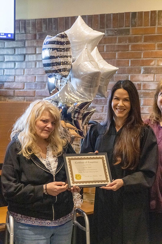 Community Court graduate Yvonne Baker holds her graduation certificate with Monore Municipal Judge Jessica Ness (at right) Friday, Feb. 3.