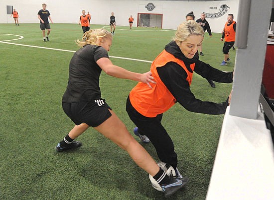 Snohomish County Steelheads team midfielders Anna Roslander (left) and M’ily Morton dig for possession of the ball along the boards during a team practice at the Snohomish Sports Dome on Wednesday, March 8.