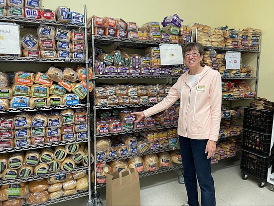 Snohomish Community Food Bank volunteer Kathy Evans stands by the bread stocks of the food bank in October.
