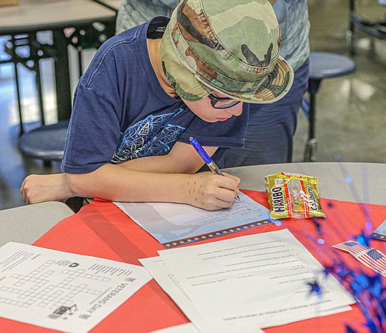 Aidan Anderson, 11, from Snohomish concentrates on composing his letter to a service person during a Glacier Peak Cubs program Wednesday, Nov. 9.