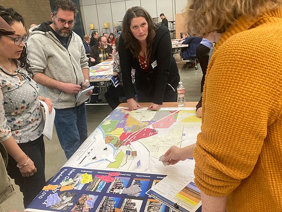 Residents such as Misty Blair (standing at table) and Mariana Medina (far left) survey Monroe’s current zoning map for a game on where people suggest upzones and changes to allow 5,000 more residents in the next 20 years at the April 13 event at Park Place Middle School.