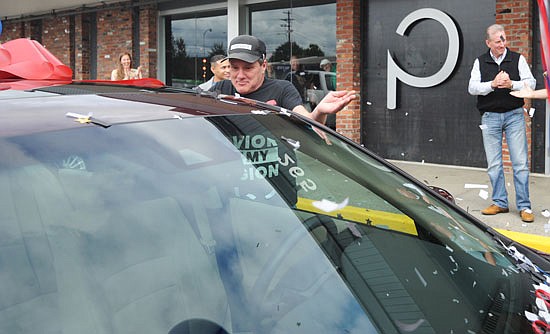 With confetti flying around him, Don Childs checks out his new car when it was presented to him at a celebration in front of The Pursuit Church in Snohomish on Saturday, Aug. 13. Mike Fischer, wearing a vest and white shirt, claps behind him.
