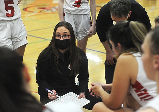 Morgan Green is back: The former basketball and soccer player now is a teacher at Snohomish High School and assistant coach with the Panthers girls basketball team. Above, Green plots strategies while surrounded by the team during a timeout at the Jan. 14 game against Burlington-Edison.