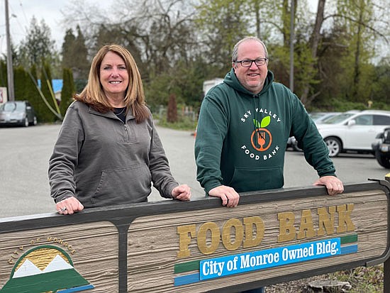 Retired director Cindy Chessie and new director Matthew Campbell pose for a photo at the food bank’s main sign.