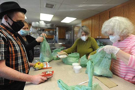 Community Kitchen volunteers, including Patrick Dunican (front left), Joyce Yates (front right), Deeann Fuchs (rear left) and Madeline Renkens (rear right) prepare to-go bags Thursday, Feb. 24 to provide a salad, sandwich and chips.