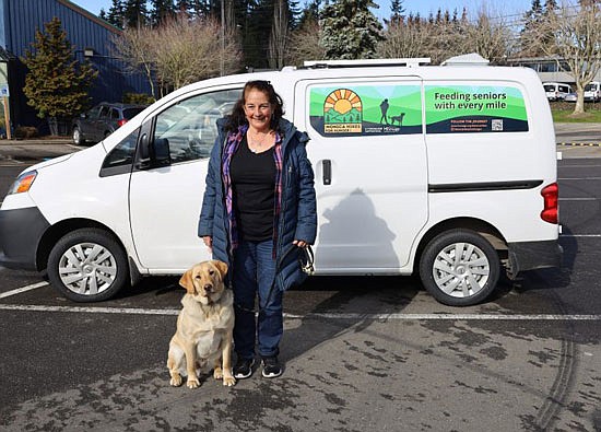 Monica Reinoso and her dog Theodore in front of the support van that’s following her along the route.