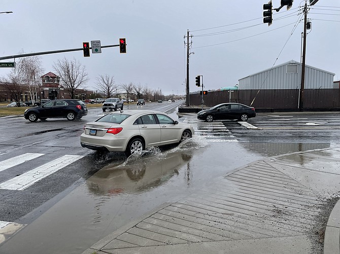A car drives through local flooding at Roop Street and Little Lane on Friday afternoon