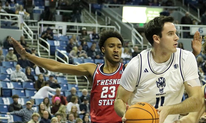 Nevada forward Nick Davidson (11) looks for an open player with Fresno State’s Leo Colimerio (23) behind him during Friday night’s at Lawlor Events Center.