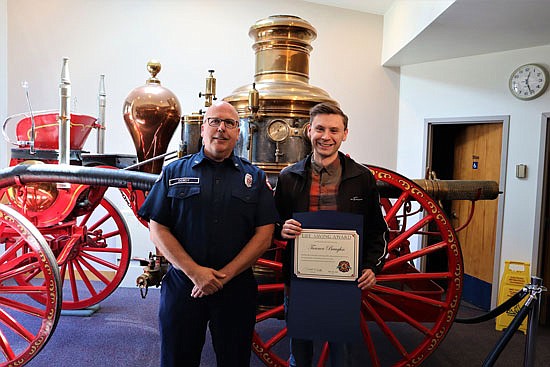 Firefighter Tim Dowdy (left) presents Tanner Baughn (right) a Life Saving Award at Fire District 4.