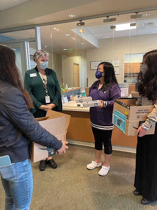 Members of Telehealth for Seniors bring boxes of devices to a representative of Community Health Centers of Snohomish County at its Administration Office in Everett on Tuesday, Sept. 14.