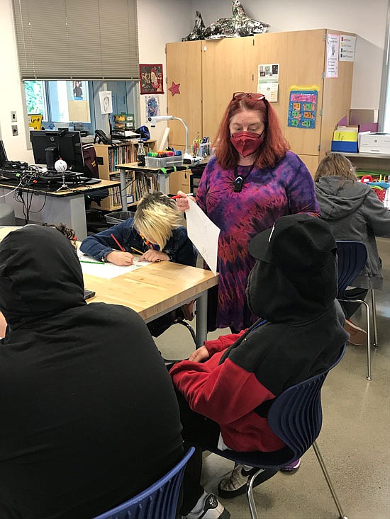 Cynthia Gaub, the state’s Art Educator of the Year, connects with students for class. Here, Gaub (standing) chats with a student in her classroom in October.