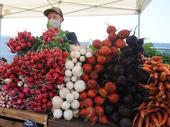 James Bernston of Radicle Roots Farm, a small outfit in Snohomish, displays radishes and other produce during the 2020 Snohomish Farmers Market.