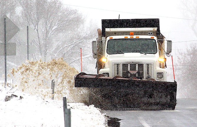A Douglas County snowplow cleans up the edges on Main Street in Genoa on Sunday.