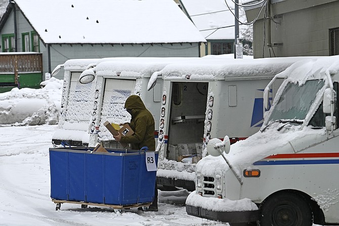 A mail carrier loads a mail truck with mail on March 1 in Lake Tahoe, Calif.