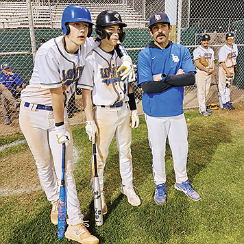 Lowry’s Kaysin Garner, Matthew Casalez and assistant coach Pachi Bengochea wait in the on deck circle for the inning to begin.