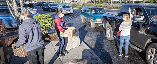 Members of Provide Hope, which partners with The Rock Church, greet folks and load food boxes on Wednesday, Dec. 23 for the drive-through food pantry outside The Rock Church in Monroe, 16891 146th St. SE off of Fryelands Boulevard.