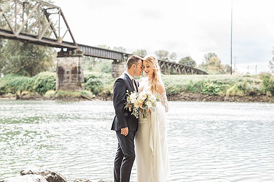 Lauren and Adam Matherly, who eloped at Belle Chapel in Snohomish, stand on the bank of the Snohomish River for a photo taken around the time of their wedding.