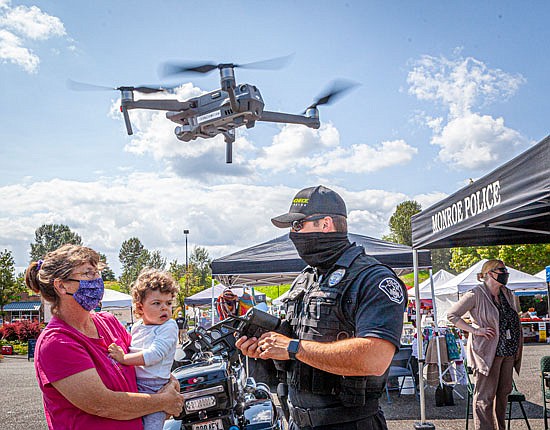 Officer Derrick Lether flies the drone and speaks to Donna and Payton, age 1, at the Monroe Farmers Market Wednesday, Aug. 12.
”I like to show (Payton) all the wonderful things,” Donna said.