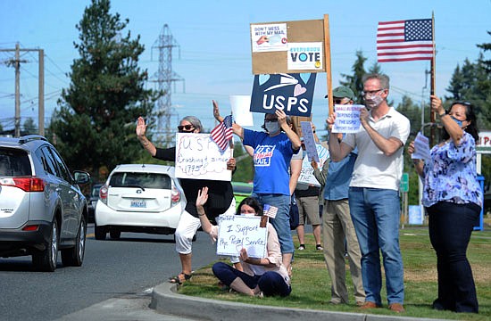 A group demonstrating in support of the U.S. Postal Service, and protesting the cutbacks to the agency, try to get the attention of motorists on Avenue D in Snohomish in front of the shoppng center that includes the post office on Saturday, Aug. 29.