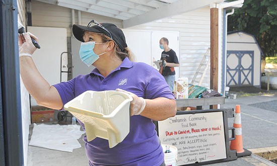 Volunteers Nile Arkush (left) and Norman Cooper (right) use a primer paint to touch up spots that had been scraped of old paint as they worked last week on preparing the Snohomish Community Food Bank for a repainting. The new paint scheme should be applied this week at the food bank off of Ferguson Road behind the Fire Station on Avenue D.