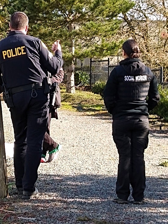 Sgt. Paul Ryan and embedded social worker Elisa Delgado approach a homeless man who was standing near a fence on the trail near Ixtapa restaurant. They are part of the Monroe Police Department’s social outreach team that encounters people and works to try to help them.